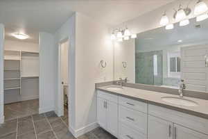 Bathroom with vanity, toilet, a textured ceiling, and tile patterned flooring