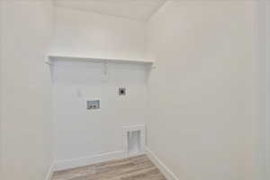 Laundry room with light hardwood / wood-style flooring, washer hookup, and electric dryer hookup