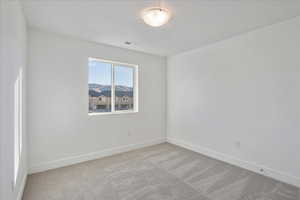 Unfurnished room with light carpet and a mountain view