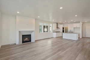 Unfurnished living room with sink and light hardwood / wood-style floors