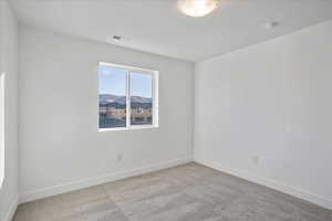 Spare room featuring a mountain view and light colored carpet