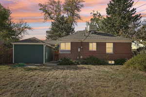 Back house at dusk with a lawn