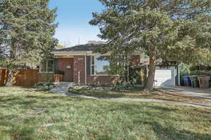 View of front facade featuring a front yard and a garage