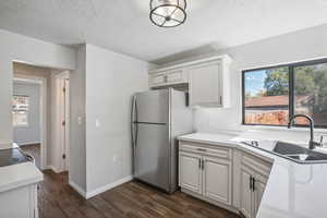 Kitchen with stainless steel refrigerator, sink, plenty of natural light, and dark hardwood / wood-style flooring