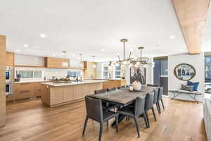 Dining room featuring sink, an inviting chandelier, and light wood-type flooring