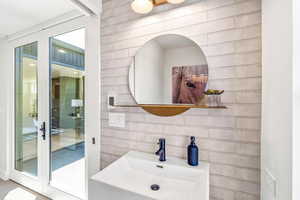 Bathroom with tasteful backsplash, tile walls, and sink