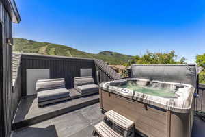 Wooden terrace featuring a hot tub and a mountain view