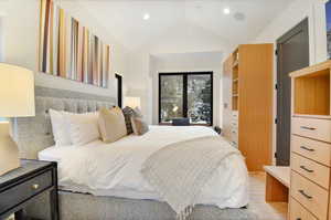 Bedroom with lofted ceiling and light hardwood / wood-style flooring