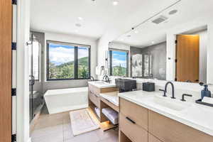 Bathroom with vanity, shower with separate bathtub, and tile patterned flooring