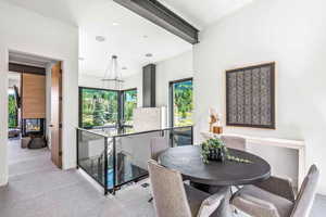 Dining area with a multi sided fireplace and light colored carpet