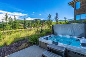 View of patio featuring a hot tub and a mountain view