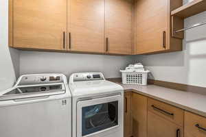 Laundry room featuring cabinets and washing machine and clothes dryer