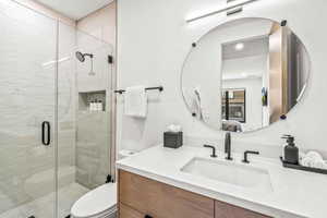 Bathroom with vanity, toilet, and an enclosed shower