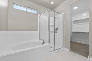 Bathroom with separate shower and tub and tile patterned flooring