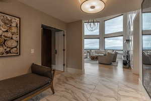 Corridor featuring light hardwood / wood-style floors and an inviting chandelier