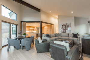 Living room with high vaulted ceiling, beamed ceiling, and light wood-type flooring