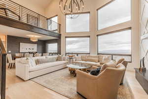 Living room featuring a mountain view, a towering ceiling, an inviting chandelier, and light wood-type flooring