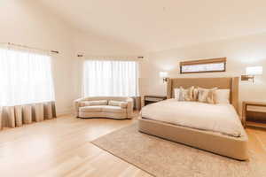 Bedroom with hardwood / wood-style flooring and vaulted ceiling