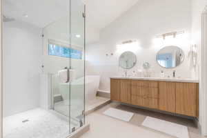 Bathroom with tile patterned floors, independent shower and bath, vaulted ceiling, tile walls, and vanity