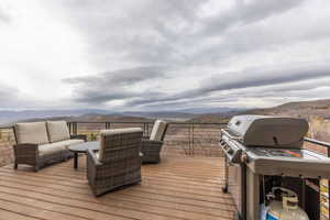 Wooden deck with a mountain view and a grill