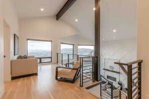 Interior space featuring a mountain view, hardwood / wood-style flooring, high vaulted ceiling, and beam ceiling