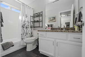 Full bathroom with vanity, toilet, tile patterned floors, and shower / bathtub combination with curtain