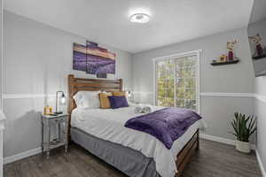 Bedroom featuring a textured ceiling and dark hardwood / wood-style flooring