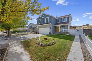 View of property with a porch, a front lawn, and a garage