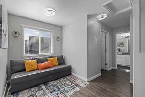 Living room with a textured ceiling and dark wood-type flooring