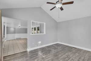 Spare room featuring ceiling fan, lofted ceiling, and hardwood / wood-style floors