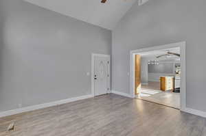 Interior space featuring light hardwood / wood-style floors, high vaulted ceiling, and ceiling fan