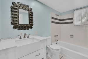 Full bathroom featuring vanity, toilet, tile patterned floors, and tiled shower / bath