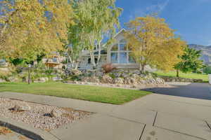 View of front facade featuring a front yard, a mountain view, and a porch