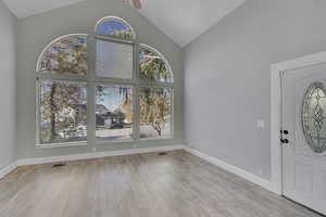 Entryway featuring light hardwood / wood-style floors, high vaulted ceiling, and ceiling fan