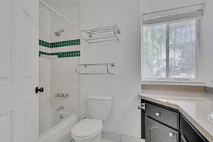 Full bathroom with vanity, toilet, and tiled shower / bath combo