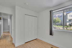 Unfurnished bedroom with a closet and light wood-type flooring