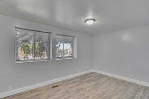 Unfurnished room featuring a textured ceiling and hardwood / wood-style floors