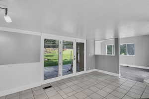 Unfurnished room featuring light tile patterned flooring, a textured ceiling, and plenty of natural light