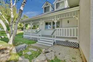 Entrance to property with a porch and a lawn