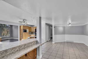 Kitchen featuring light tile patterned floors, a textured ceiling, backsplash, and ceiling fan