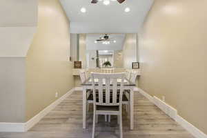 Dining area with light hardwood / wood-style flooring and ceiling fan