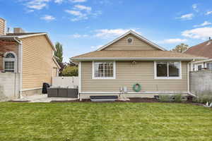 Rear view of house featuring an outdoor living space, a patio area, and a lawn