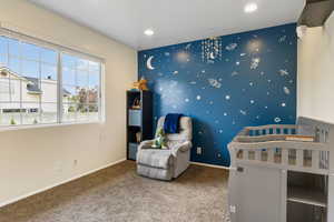 Bedroom with carpet floors and a crib