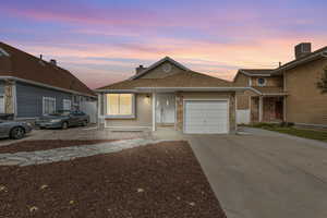 View of front of property featuring central AC and a garage