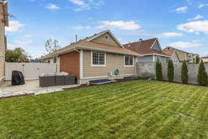 Rear view of house featuring a yard, an outdoor living space, and a patio area