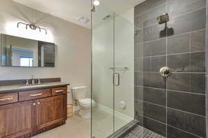 Bathroom with vanity, tile patterned flooring, toilet, and walk in shower. Private bath