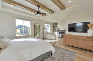 Bedroom with beam ceiling, light hardwood / wood-style floors, and ceiling fan