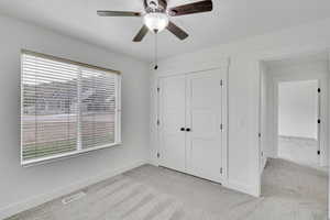 Unfurnished bedroom featuring a closet, ceiling fan, and light carpet