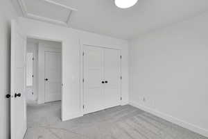 Unfurnished bedroom with light colored carpet and a closet