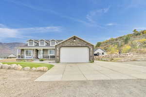 View of front of house with a mountain view, a porch, and a garage